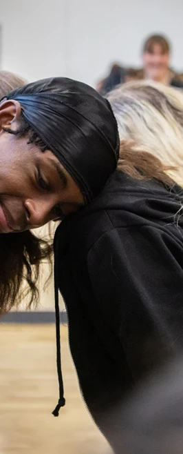 Students in a close group, leaning their heads together, sharing a relaxed and friendly moment during a drama exercise in the studio. Students in a close group, leaning their heads together, sharing a relaxed and friendly moment during a drama exercise in the studio.